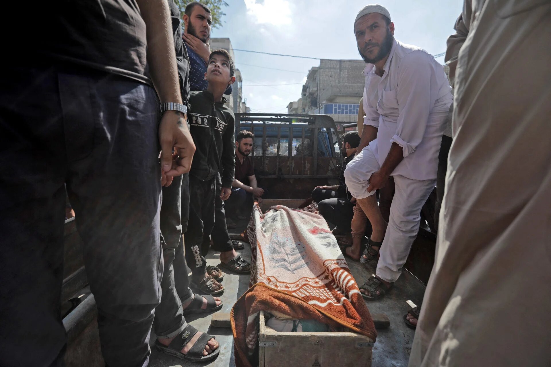 Syrians gather around the body of a victim of the battles between rival Syrian factions competing for power in al-Bab on 14 October (AFP)