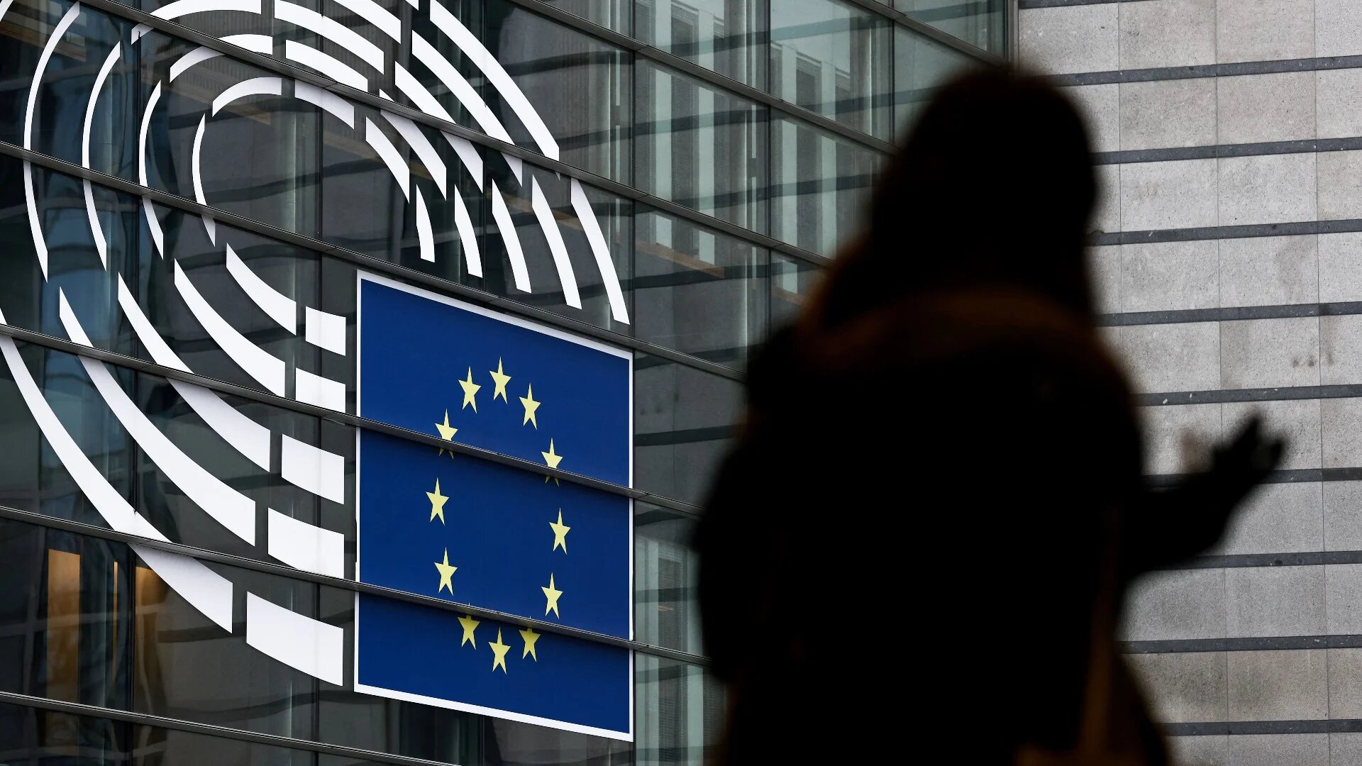 A woman walks near the entrance of the European Parliament in Brussels (AFP)