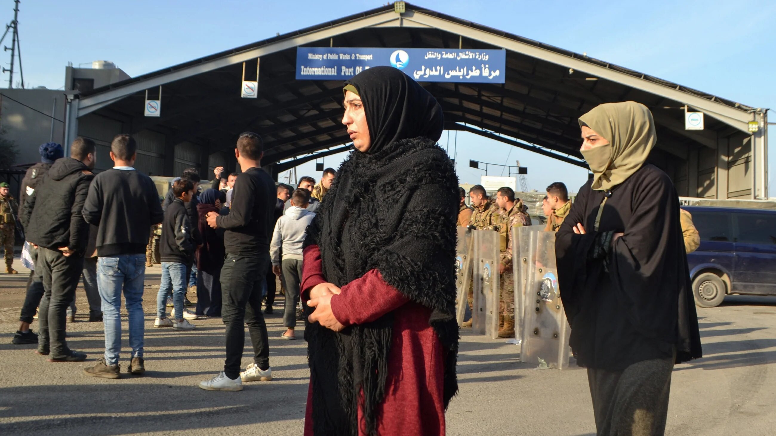 Families of boat sinking survivors in Lebanon await news of their relatives outside Tripoli port on 1 January 2023 (AFP)