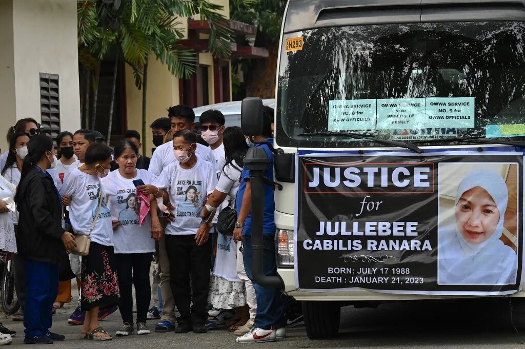 Relatives of Jullebee Ranara, a domestic helper who was killed in Kuwait, grieve during her funeral at a cemetery in Las Pinas, Metro Manila on February 5, 2023 (AFP)