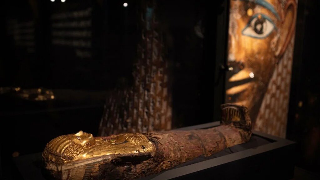 A child mummy is pictured in the Golden Mummies of Egypt exhibition in Manchester Museum ahead of the museum's reopening after a long refurbishment in Manchester, northwest England, on 13 February 2023 (AFP)