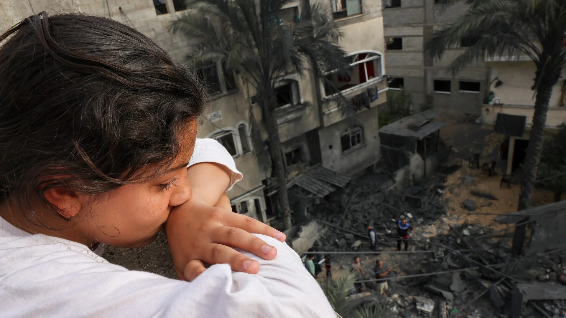 A Palestinian girl looks at the rubble of a building, following an Israeli air strike, in Beit Lahia in the northern Gaza Strip on 11 May (AFP)