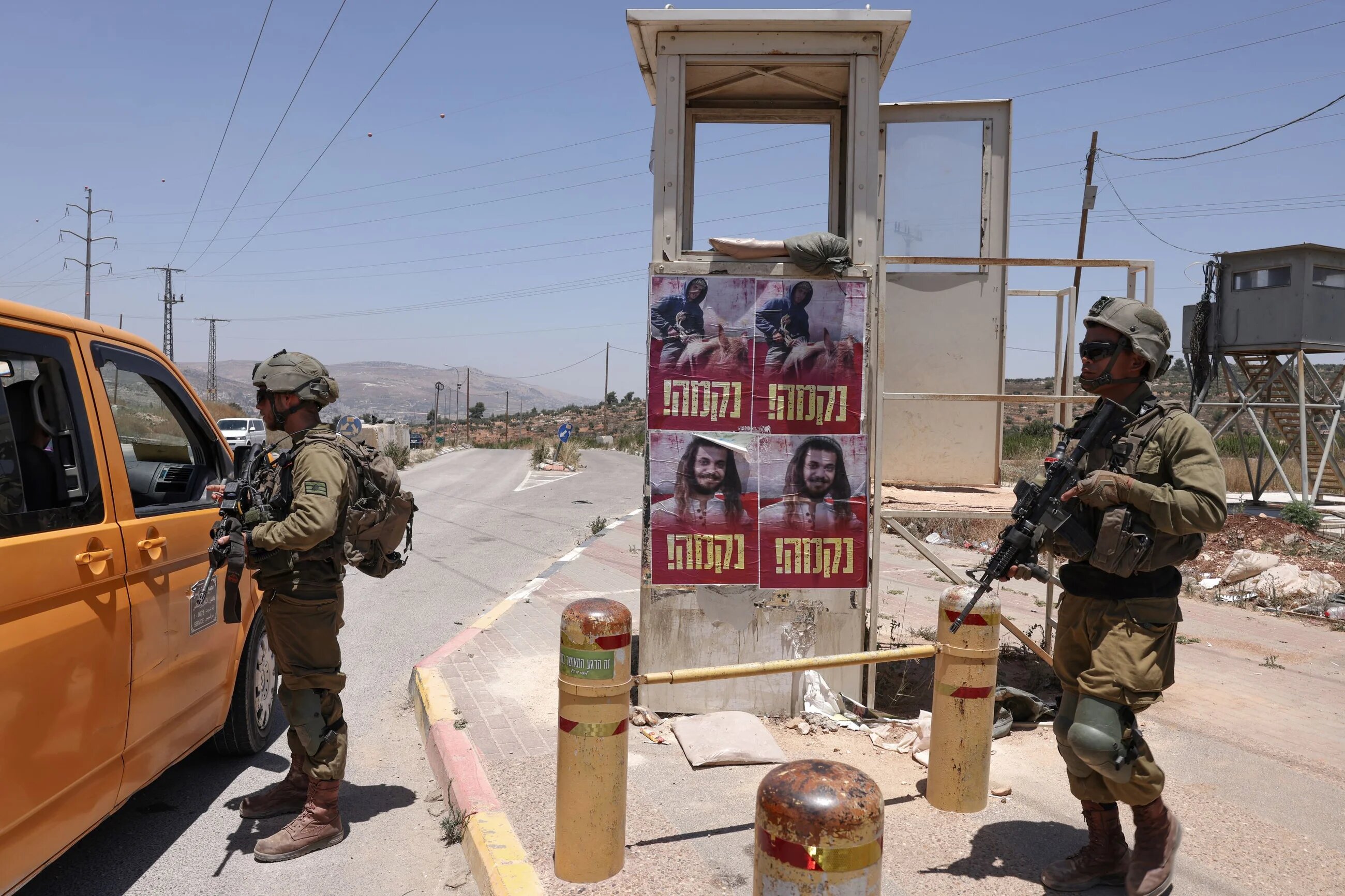 Israeli soldiers stand guard near the settlement of Kfar Tapuach in the occupied West Bank, on 25 June 2023 (AFP)
