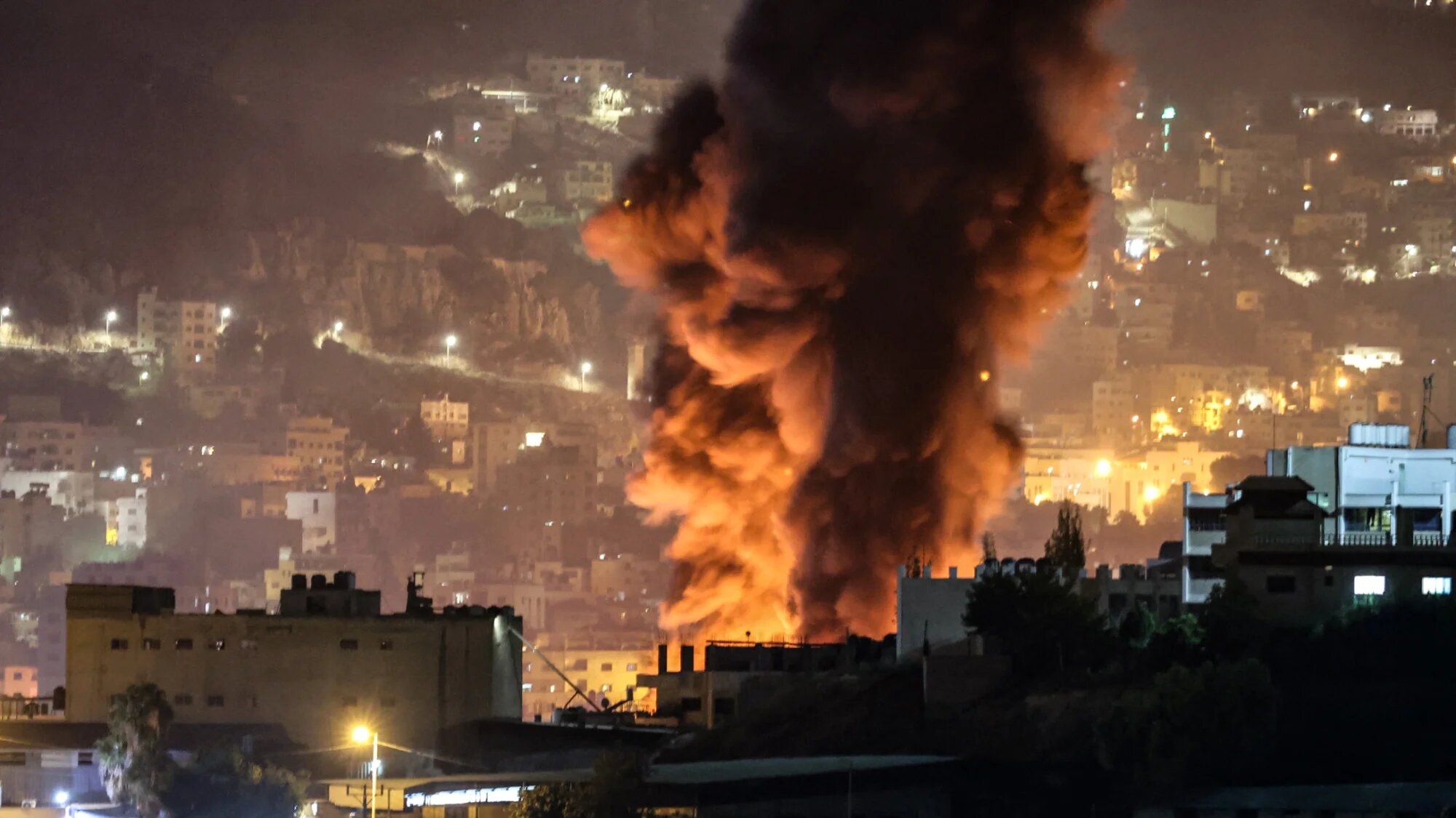 Smoke rises in Nablus during an escort of settlers to Joseph’s Tomb by Israeli forces on 4 October 2023 (AFP/Zain Jaafar)