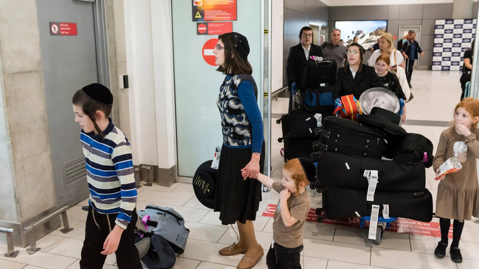 Israeli families leaving Tel Aviv arrive at Larnaca Airport in Cyprus on 12 October 2023, just days after Israel launched its war on Gaza (Iakovos Hatzistavrou/AFP)