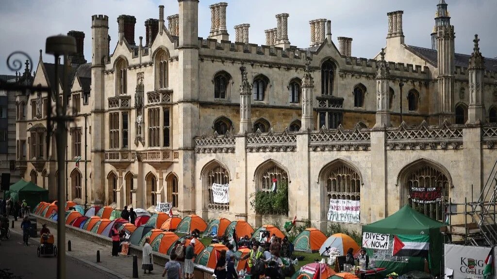 Students gather around their tents during a protest in support of Palestinian people, at Kings College Cambridge on 8 May 2024 (AFP)