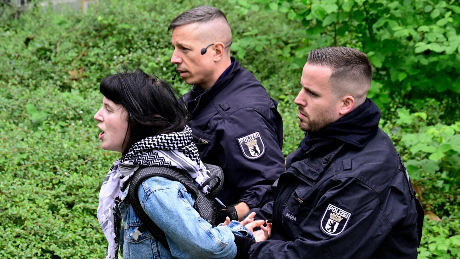 A pro-Palestine activist is led away by police officers during a demonstration against Israel's war on Gaza at the Free University of Berlin, Germany, on 7 May 2024 (Tobias Schwarz/AFP)