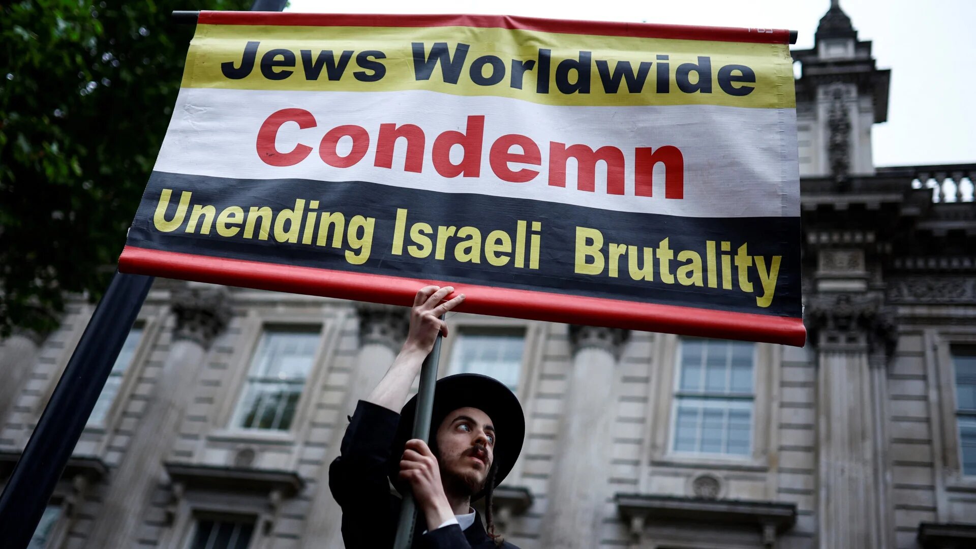 A member of the ultra-Orthodox Jewish community holds a placard outside Downing Street, central London, on 28 May 2024, during an "End the genocide" rally calling for a ceasefire in Gaza (Benjamin Cremel/AFP)