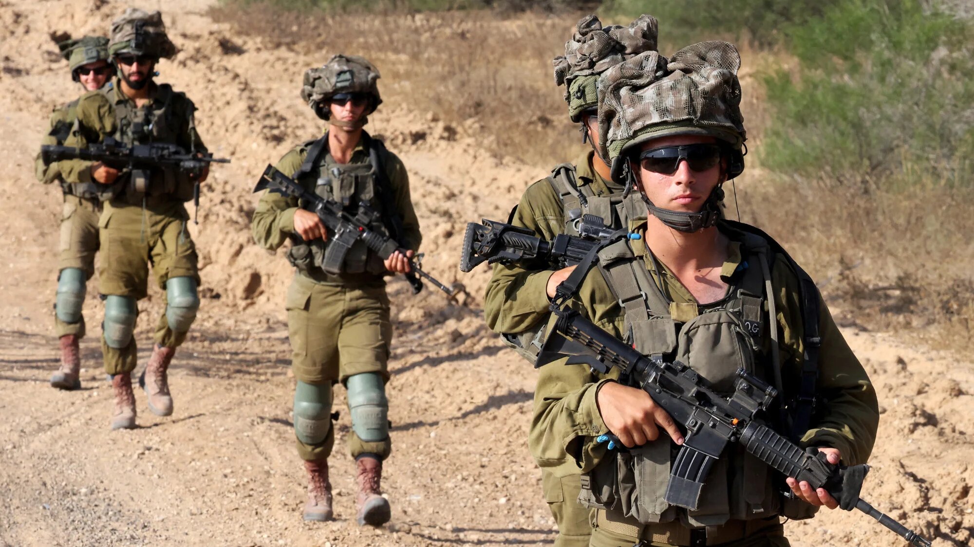 Israeli army soldiers patrol around a position along Israel's southern boundary with the Gaza Strip on 13 June 2024 (Jack Guez/AFP)