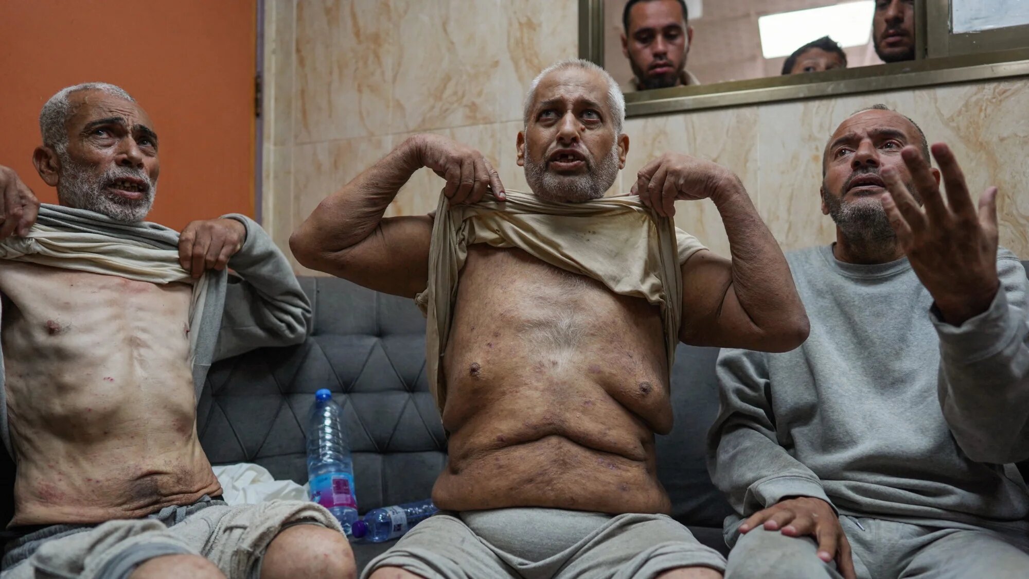 Palestinian men who had been detained by Israeli forces speak about the torture they endured as they arrive for a check-up at the Al-Aqsa Martyrs Hospital in Deir el-Balah in the central Gaza Strip on 1 July 2024 (AFP/Bashar Taleb)