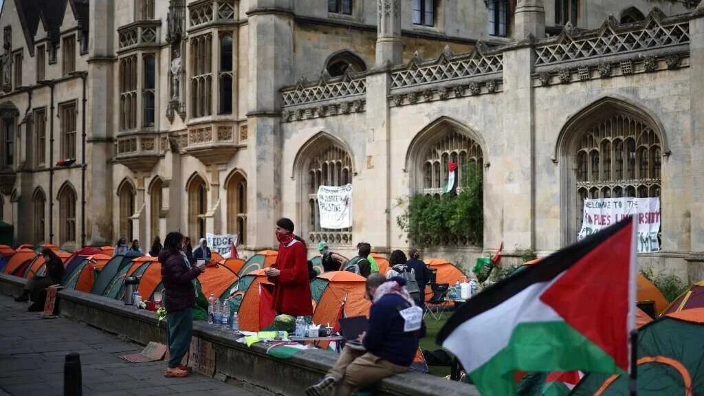 Students gather around their tents during a protest against Israel's genocide in Gaza at Kings College at Cambridge University in Cambridge, eastern England on May 7, 2024. (AFP)