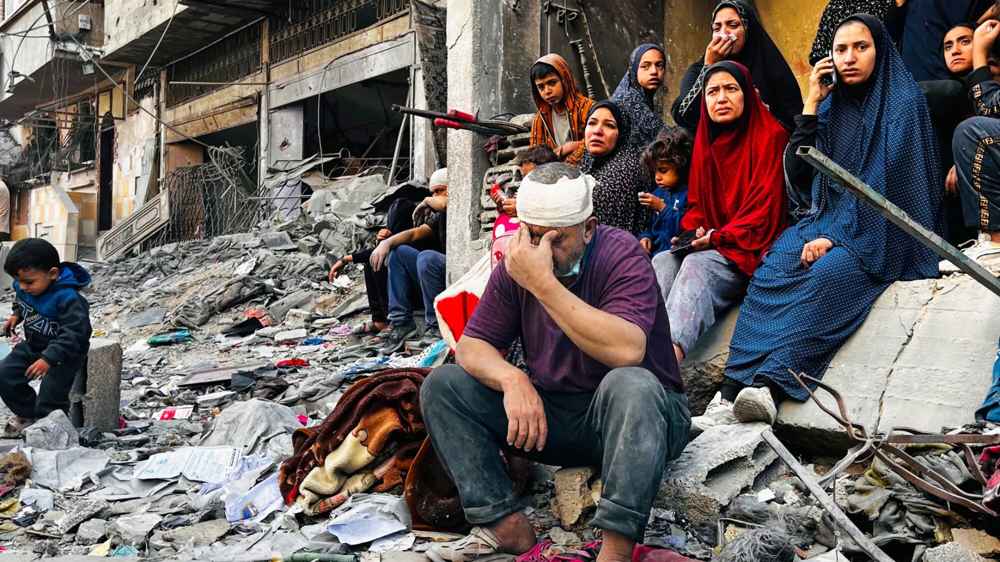 An injured man reacts while sitting on the rubble of a building hit by an Israeli strike in Beit Lahia, in the northern Gaza Strip, on 29 October 2024 (AFP)
