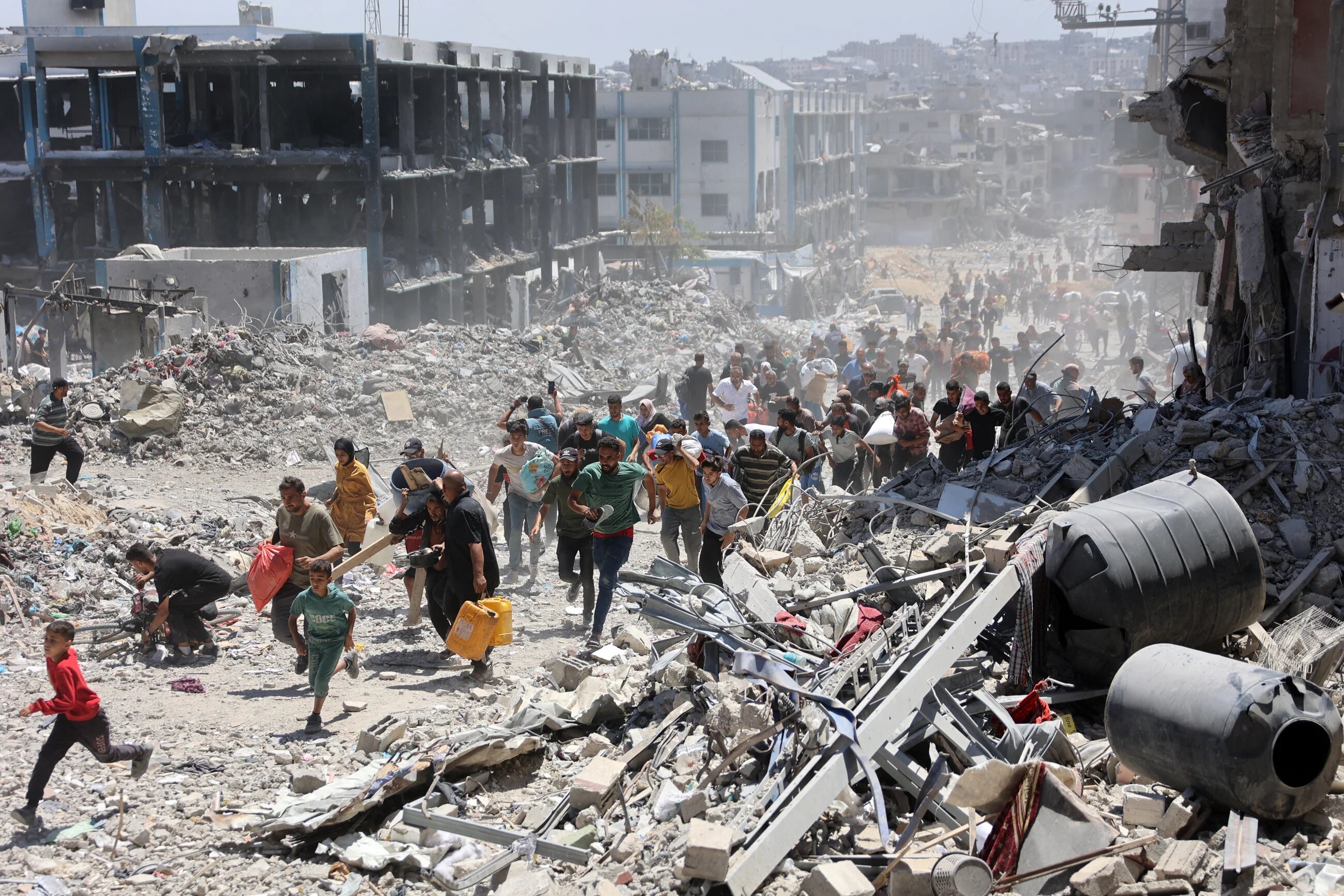 Palestinians in northern Gaza run for cover after an Israeli strike hit a school on 30 May 2024 (AFP/Omar al-Qattaa)