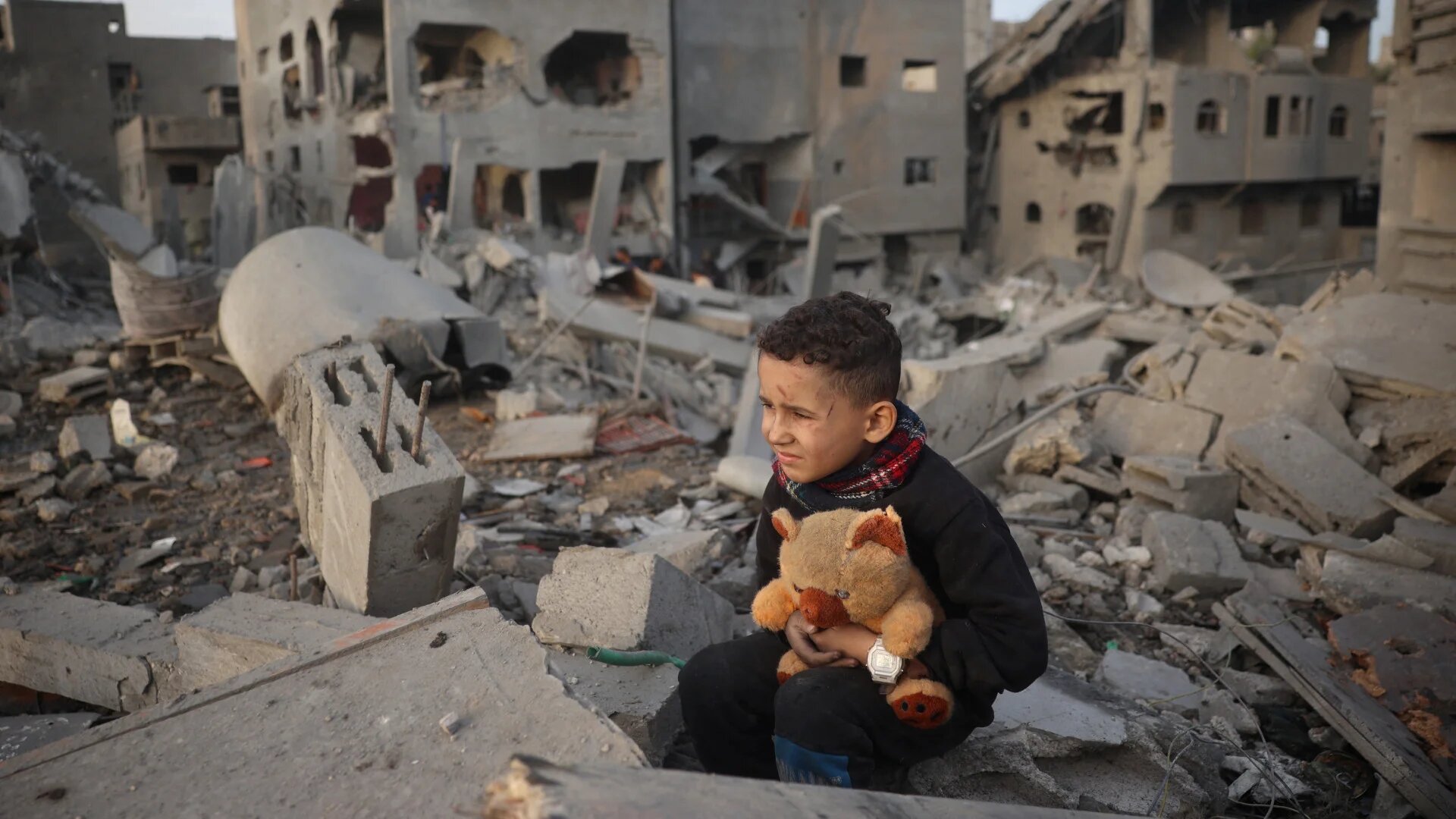 A Palestinian boy sits atop the rubble of a building, destroyed in an Israeli strike, in the Nuseirat refugee Camp in the central Gaza Strip on 7 December 2024 (Eyad Baba/AFP)