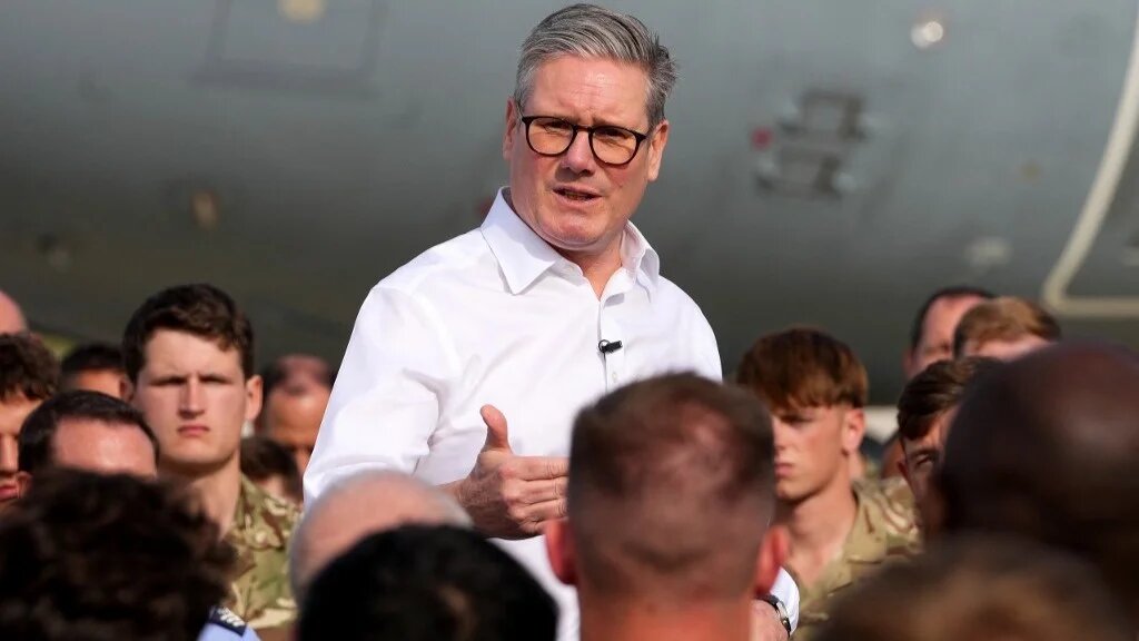 Britain's Prime Minister Keir Starmer talks to personnel at the RAF base in Akrotiri, Cyprus, on 10 December (AFP)