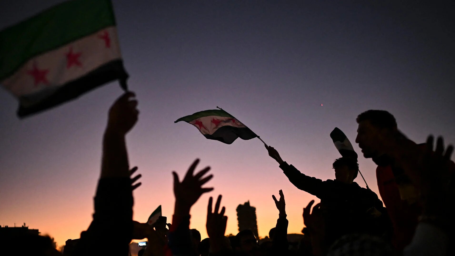 Syrians celebrate the fall of Bashar al-Assad's rule at the main Umayyad square in Damascus, on 13 December 2024 (Aris Messinis/AFP)