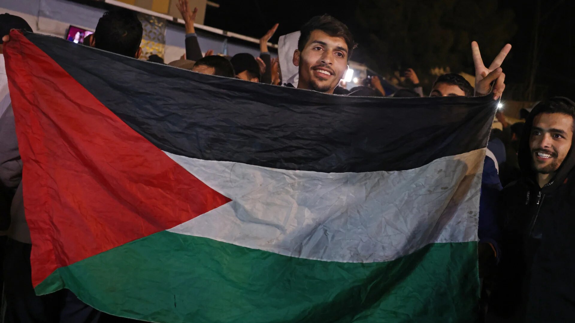 Palestinians celebrate along a street in Khan Younis in the southern Gaza Strip following an announcement that a ceasefire deal between Israel and Hamas had been reached after 15 months of war, on 15 January 2025 (Bashar Taleb/AFP)