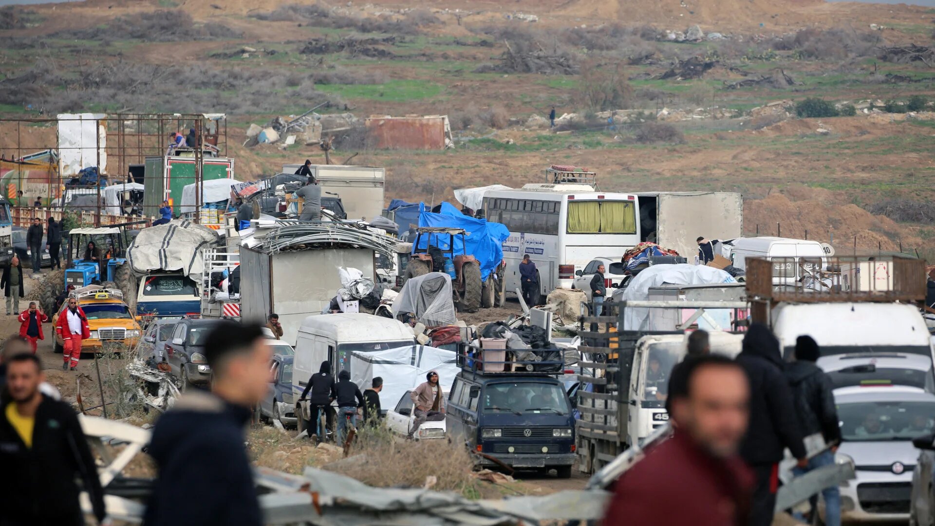 Displaced Palestinians wait to cross a checkpoint manned by Egyptian and US security on Salah al-Din road in al-Mughraqa in the central Gaza Strip, on 10 February 2025, as people move towards the northern parts of Gaza following a ceasefire deal (Eyad Baba/AFP)