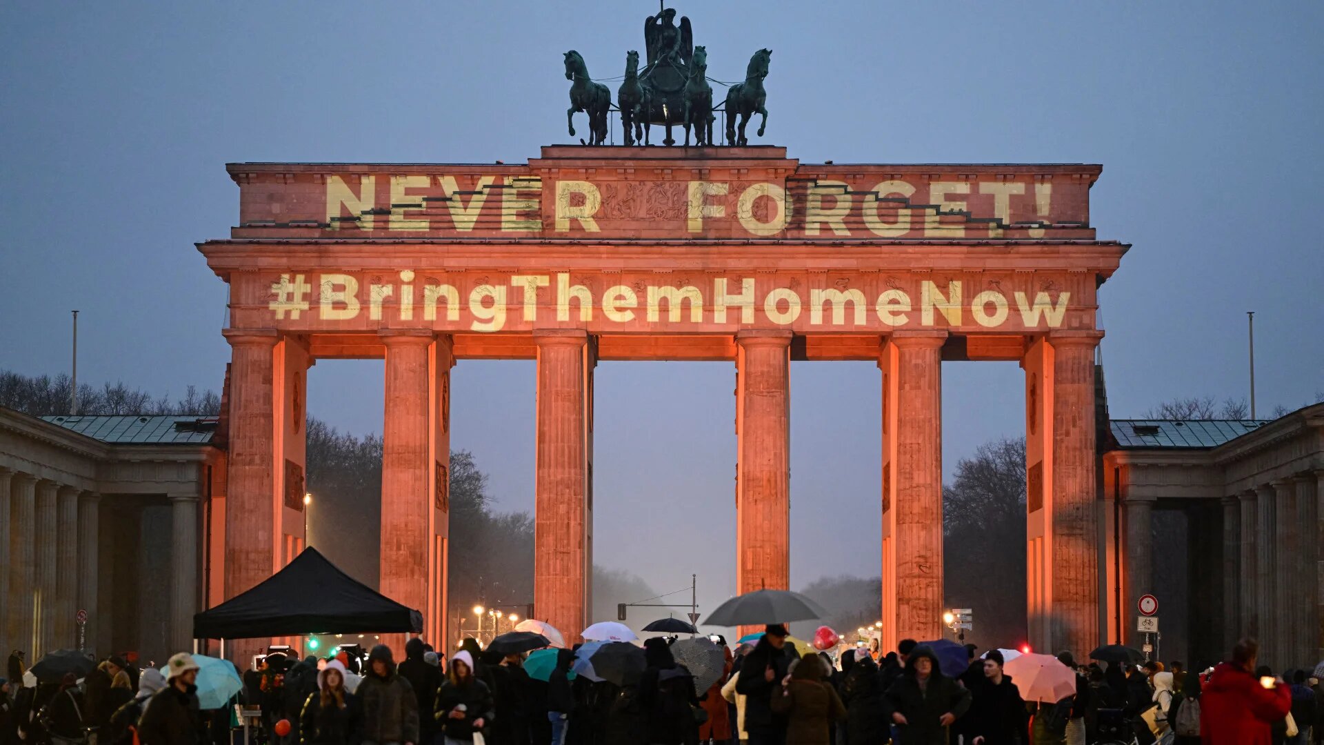 The Brandenburg Gate is illuminated with the messages “Never Forget” and “#BringThemHomeNow” during a February 2025 memorial in Berlin for Israeli hostages killed during the 7 October attacks, marking Germany’s official commemoration of the events (John MacDougall/AFP)