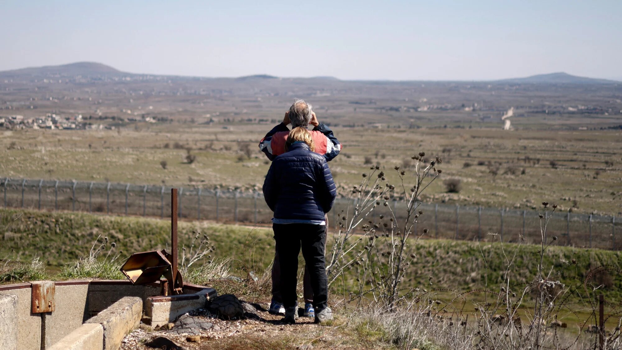 An Israeli man uses binoculars in the Israel-annexed Golan Heights, to see southern Syria's Quneitra province on 27 February 2025 (AFP/Jalaa Marey)