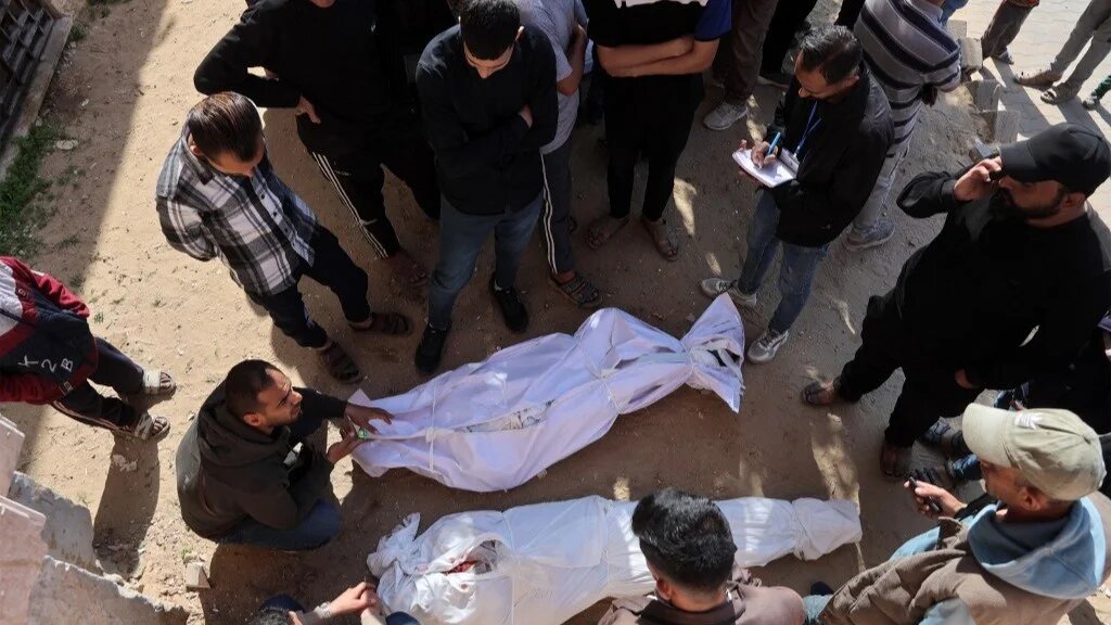 Mourners gather around the bodies of those killed by Israeli bombardment outside the Indonesian Hospital in Beit Lahia, northern Gaza Strip, on 15 March 15 2025 (AFP)
