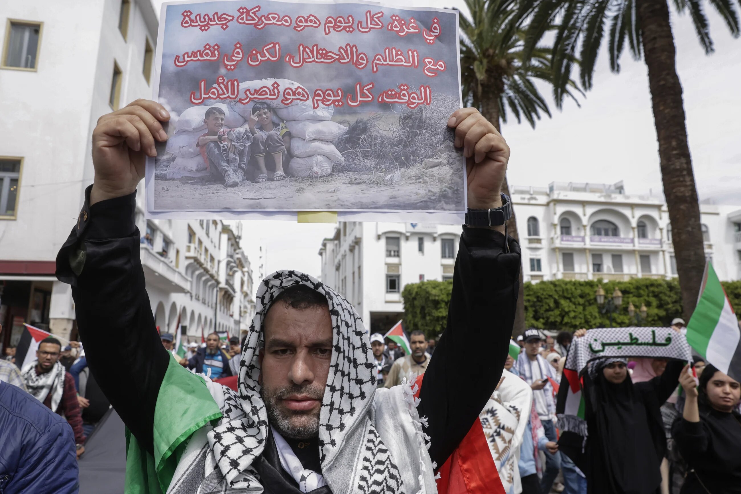 A protester holds a placard reading "In Gaza, every day is a battle with injustice and occupation, but also a victory for hope" at a march in Rabat against Morocco's normalisation with Israel, on 6 April 2025 (Abdel Majid Bziouat/AFP)