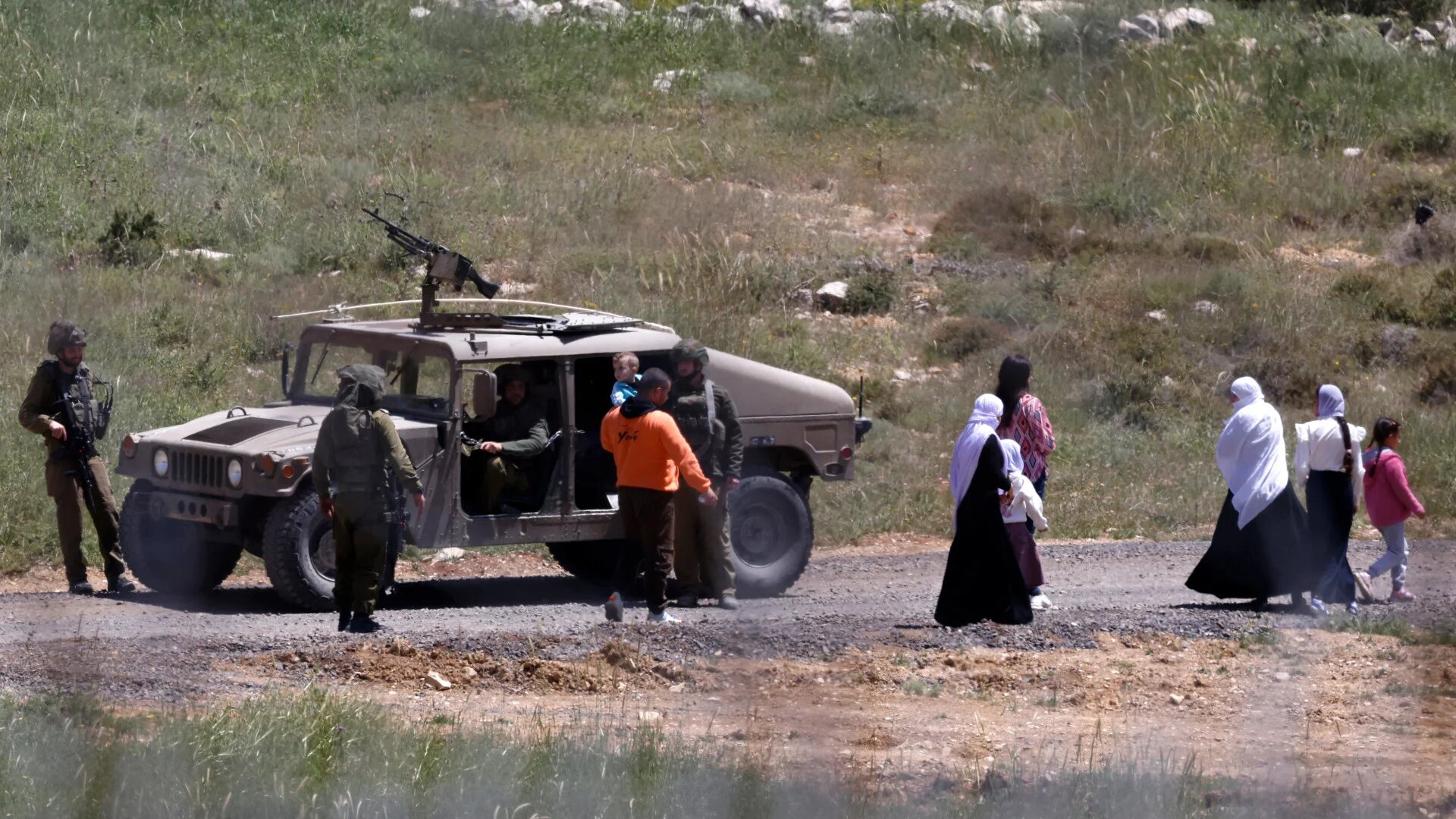 Israeli soldiers stop a Syrian Druze family from approaching the border near Majdal Shams in the Israeli-occupied Golan Heights on 3 May 2025, following sectarian violence in Damascus and Israeli strikes across Syria (Jalaa Marey/AFP)