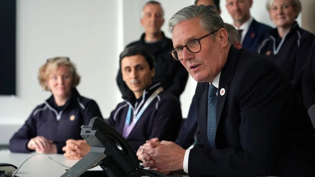 Britain's Prime Minister Keir Starmer looks on as he discusses over the phone a UK-US trade deal with US President Donald Trump at a car factory in the West Midlands, central England on May 8, 2025