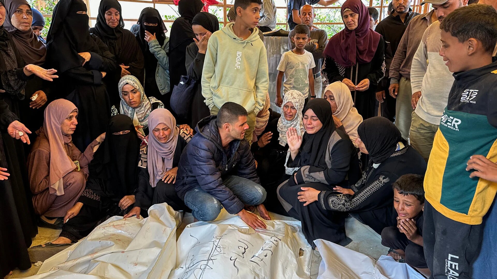 Palestinians mourn relatives killed in Israeli strikes on displacement tents in Al-Mawasi, where at least 22 were killed and over 100 wounded, at Nasser Hospital in Khan Younis on 18 May 2025 (AFP)