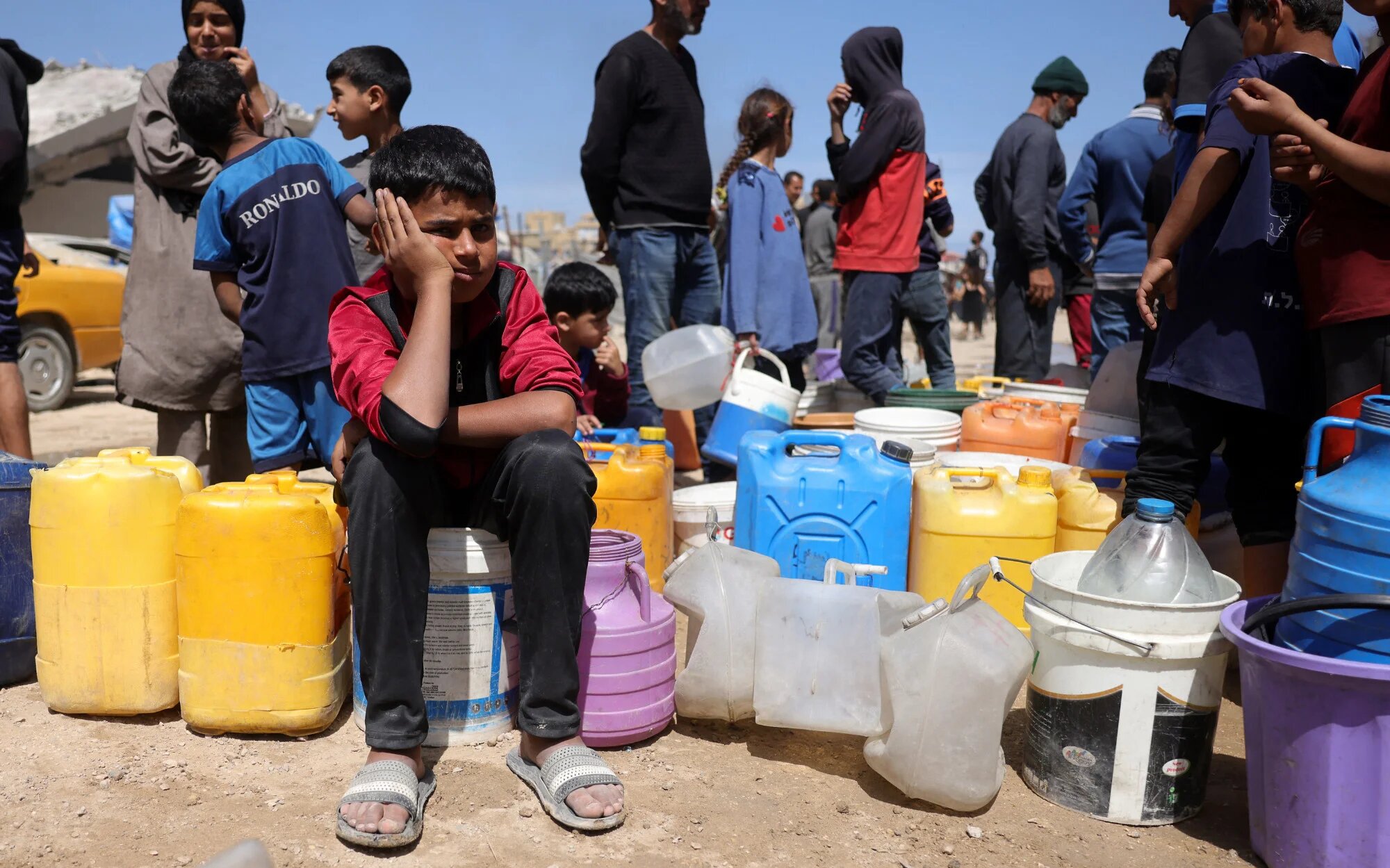 Palestinians attempt to collect water at a camp for displaced people in Gaza City on 20 May 2025 (AFP/Bashar Taleb)