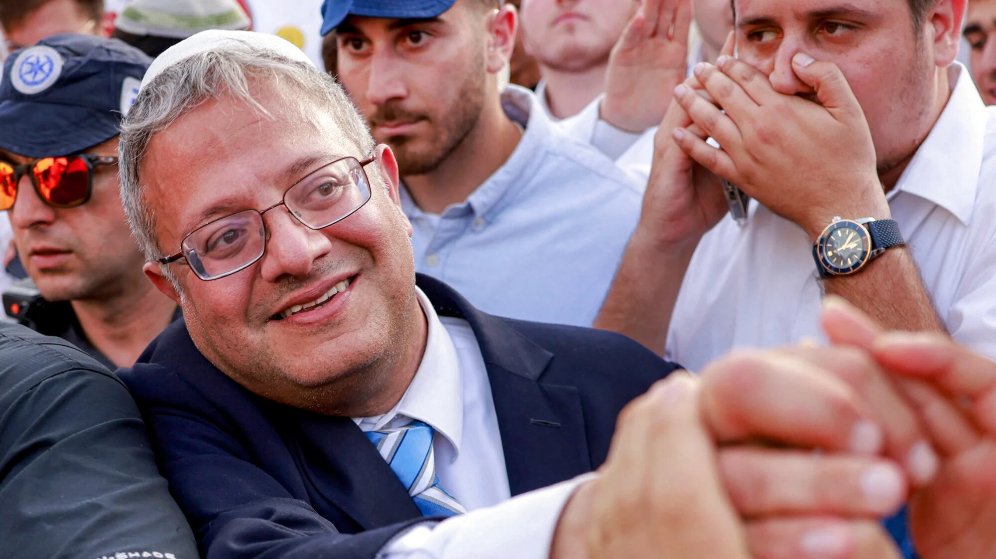 Israeli Minister of National Security Itamar Ben-Gvir reaches out to a supporter as he walks outside the Damascus Gate of the walled Old City of Jerusalem on 26 May 2025 (AFP/Menahem Kahana)