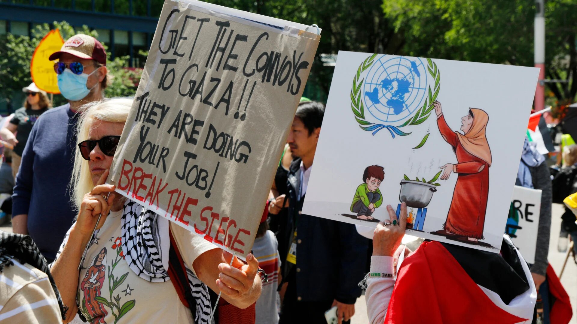 Protesters hold up signs in support of Gaza as they gather ahead of the G7 summit in Calgary, Alberta, on 15 June 2025 (Dave Chidley/AFP)