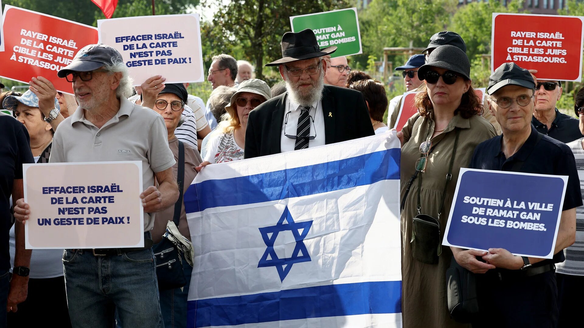 Members of the French Jewish community hold placards and the Israeli flag during a protest in Strasbourg against the city's project to twin with the Palestinian refugee camp of Aida, on 23 June 2025 (Frederick Florin/AFP)