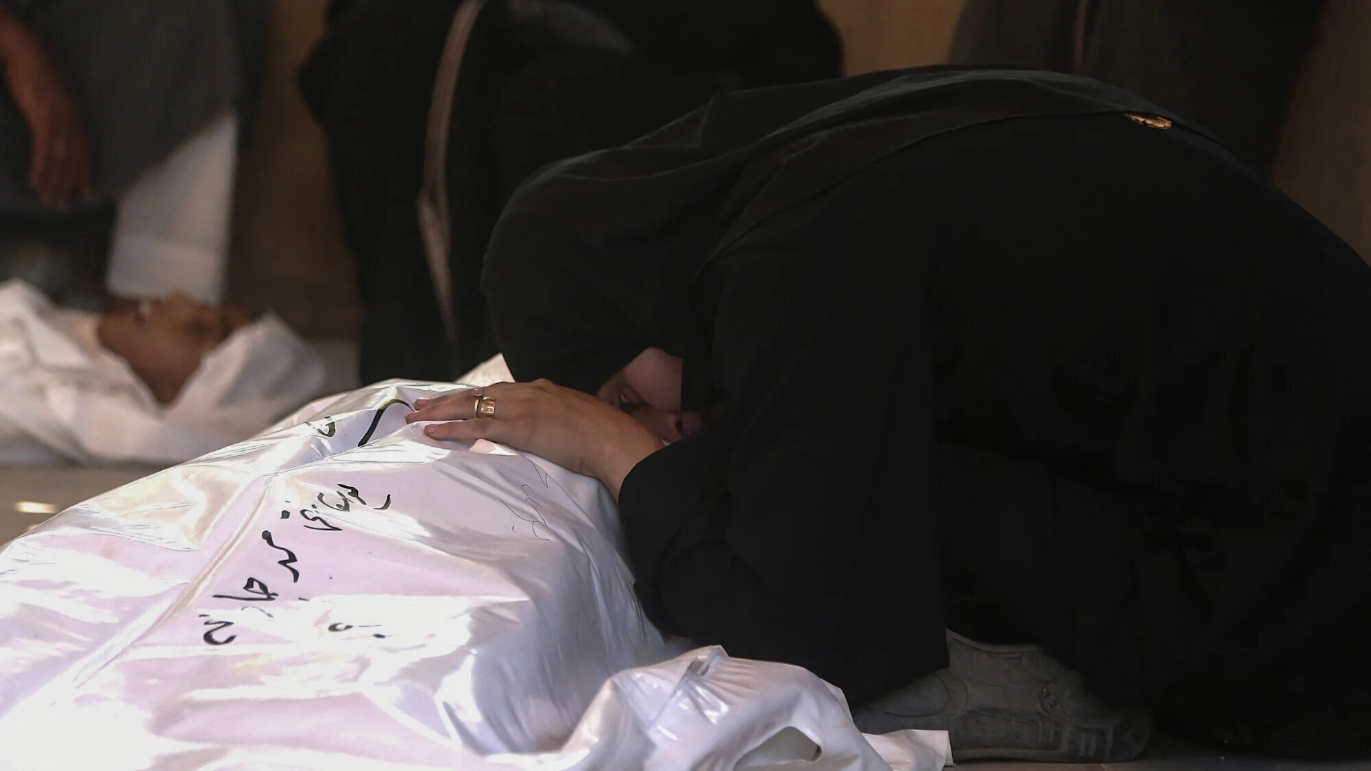 Palestinians mourn by the body of a relative killed in Israeli strikes, at Nasser hospital in Khan Yunis in the southern Gaza Strip on 22 July 2025 (AFP)