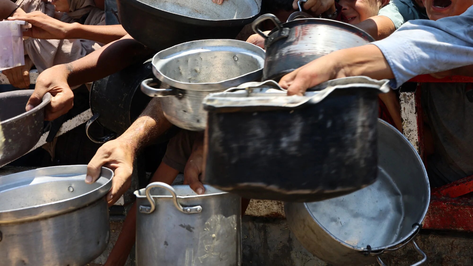 Palestinians crowd around a lentil soup distribution point in Gaza City, in the northern Gaza Strip, on 27 July 2025 (AFP/Omar al-Qattaa)