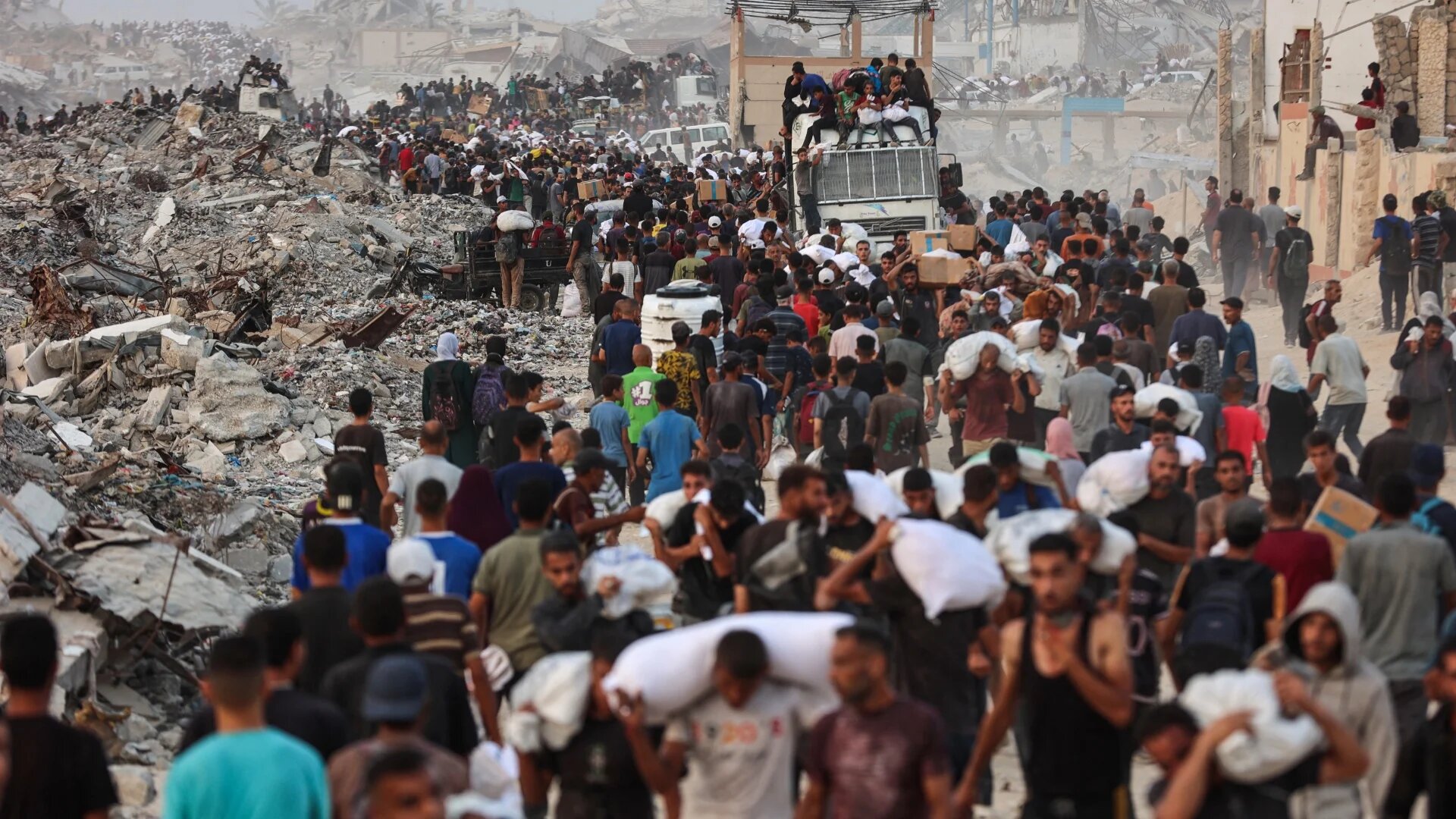 Palestinians crowd a coastal path west of Beit Lahia after receiving aid parcels on 29 July 2025, in conditions health experts warn could fuel deadly disease outbreaks (Omar Al-Qattaa/AFP)