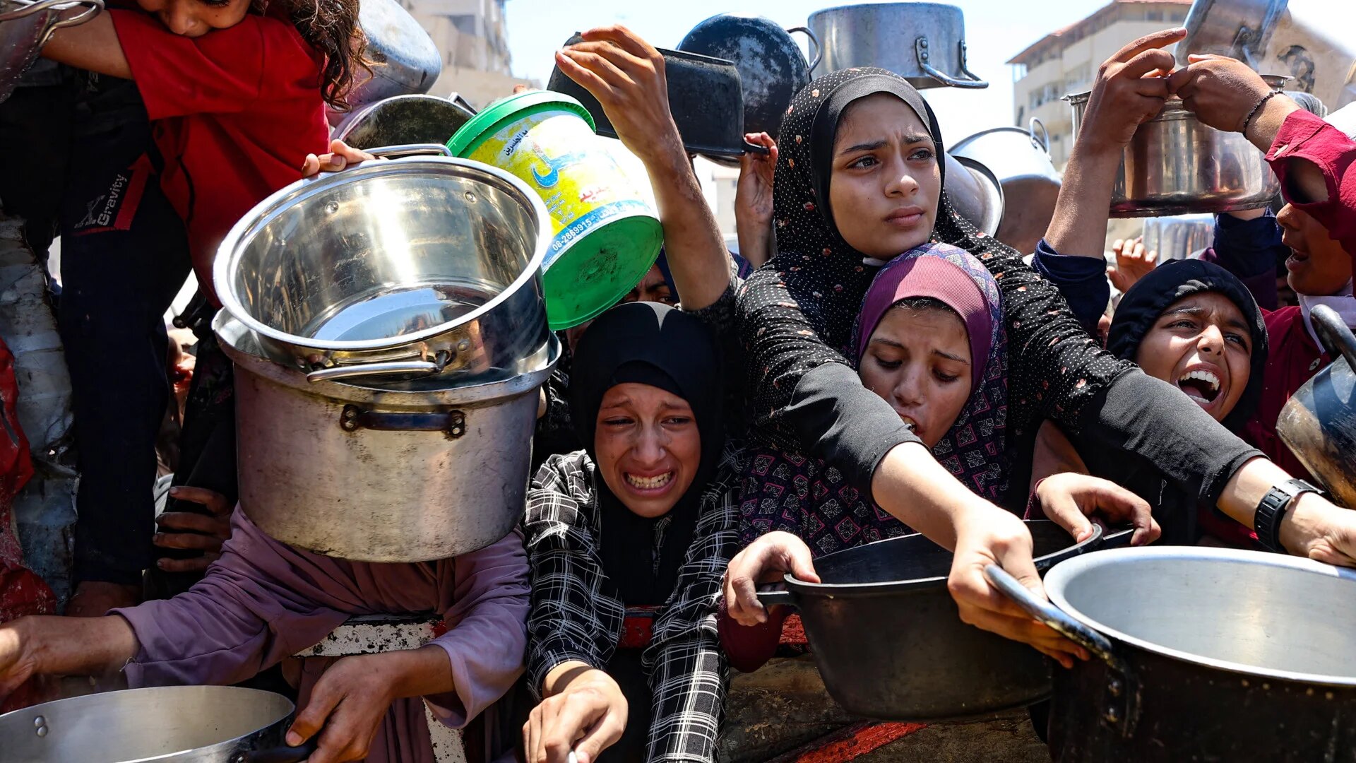 Palestinians struggle to secure lentil soup at a food distribution point in Gaza City on 2 August 2025, as the World Health Organization warns that malnutrition is reaching 'alarming levels' (Omar Al-Qattaa/AFP)