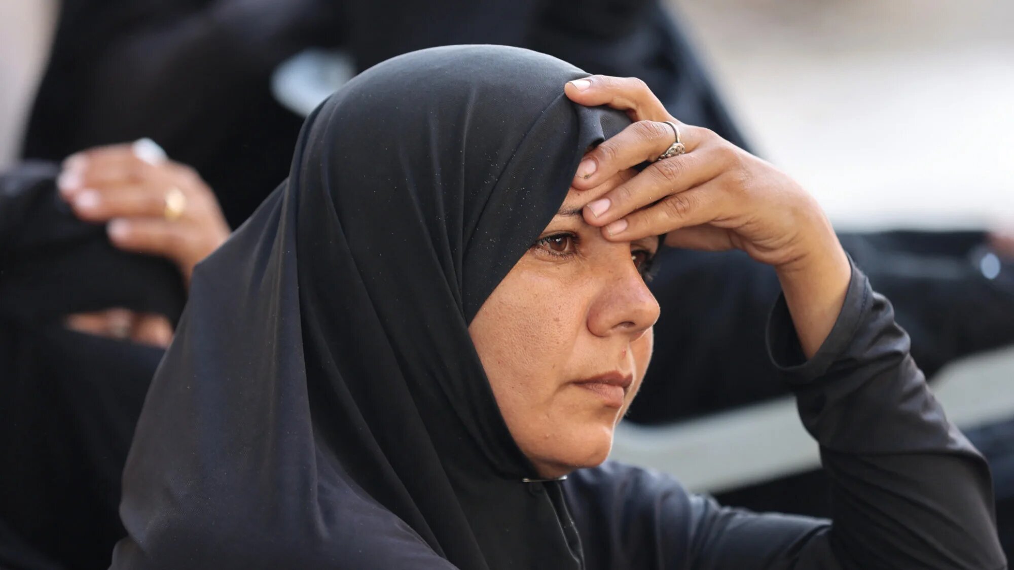 A Palestinian woman mourns relatives, killed in Israeli strikes, ahead of their funeral at Al-Shifa hospital in Gaza City on 21 August 2025 (AFP/Omar al-Qattaa)