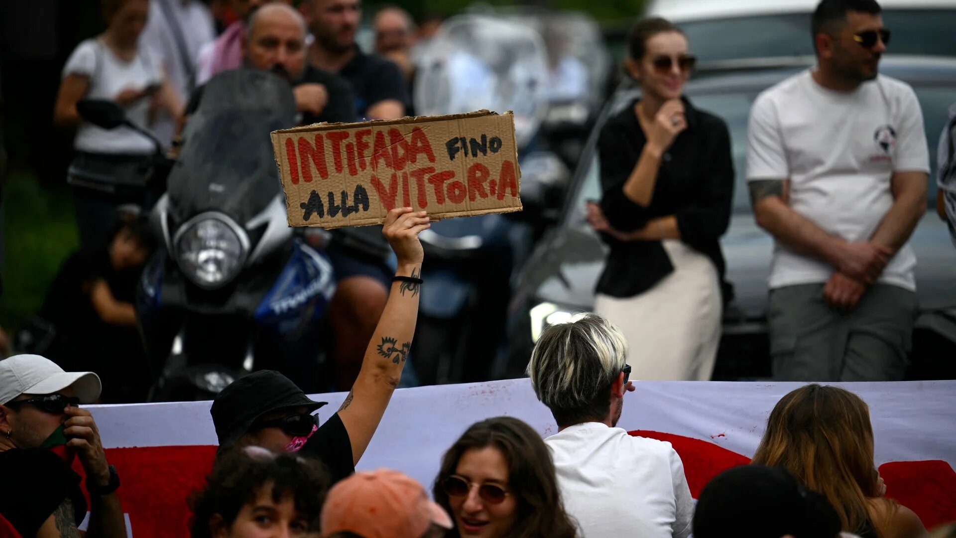 A protester blocks traffic with a placard reading "Intifada until victory" during the nationwide "Let's Block Everything" strike in solidarity with Palestinians in Gaza, in Rome on 22 September (Filippo Monteforte/AFP)