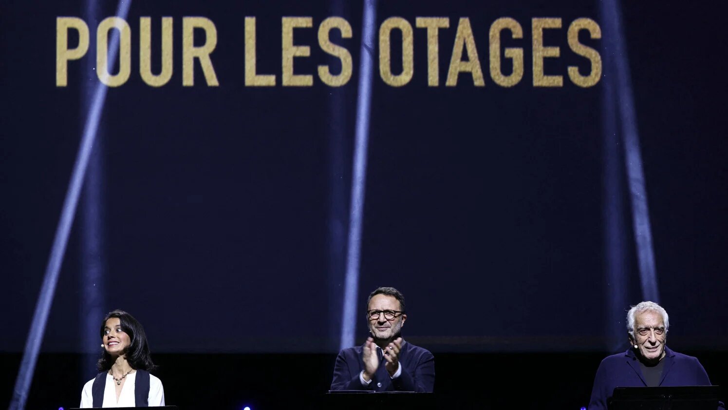 French performers Sophia Aram, Arthur and Gerard Darmon speak at a Paris rally on 5 October 2025 in memory of the 7 October victims and in support of Israeli hostages held in Gaza (Thomas Samson/AFP)