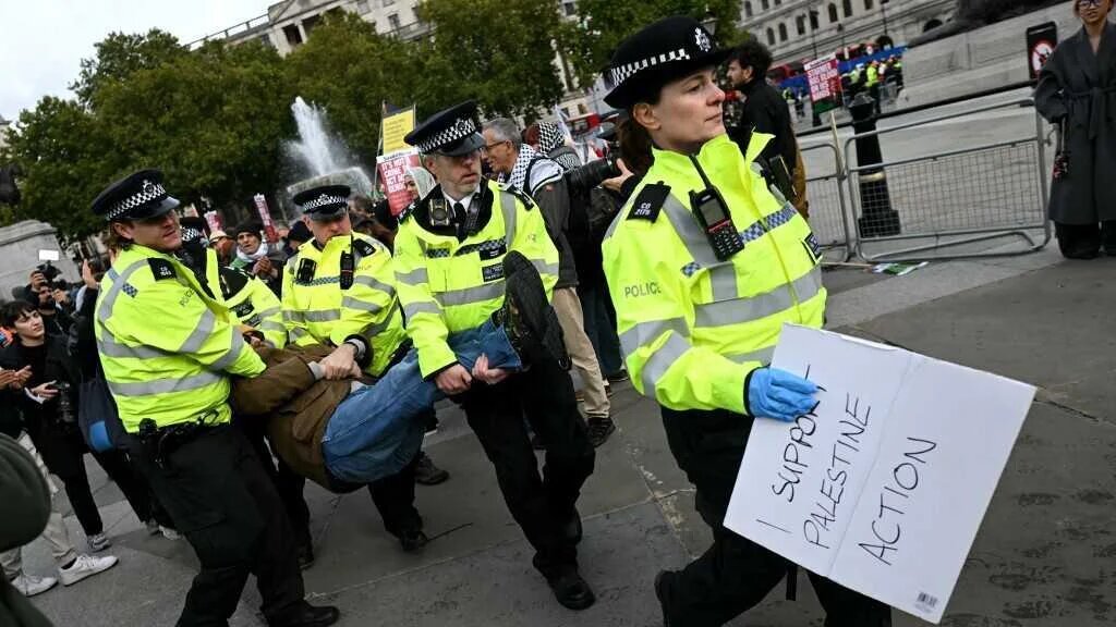A protester is taken away by police officers at a "Lift The Ban" demonstration in support of the proscribed group Palestine Action, calling for the recently imposed ban to be lifted, in Trafalgar Square, central London, on October 4, 2025.