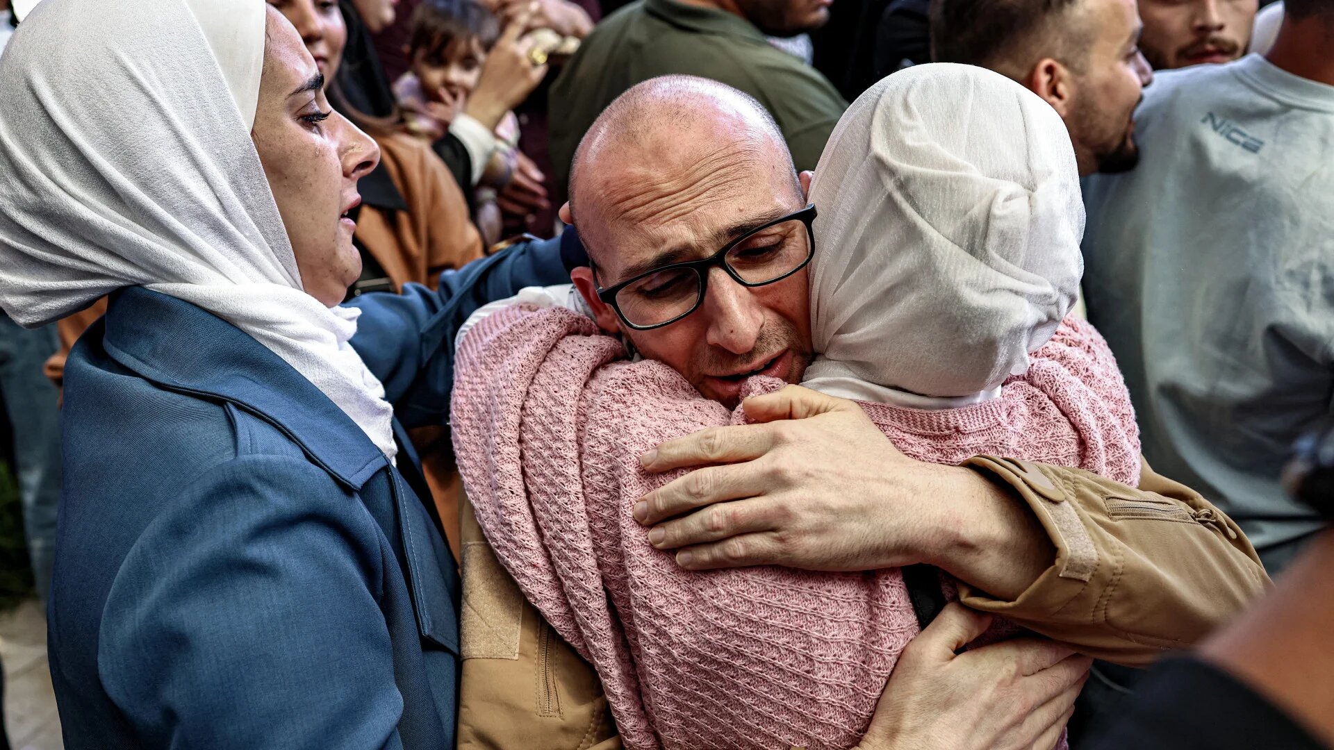 A Palestinian prisoner released in the Israel-Hamas captives exchange is embraced by a relative upon arrival at the Ramallah Cultural Centre in the occupied West Bank, 13 October 2025 (Zain Jaafar/AFP)