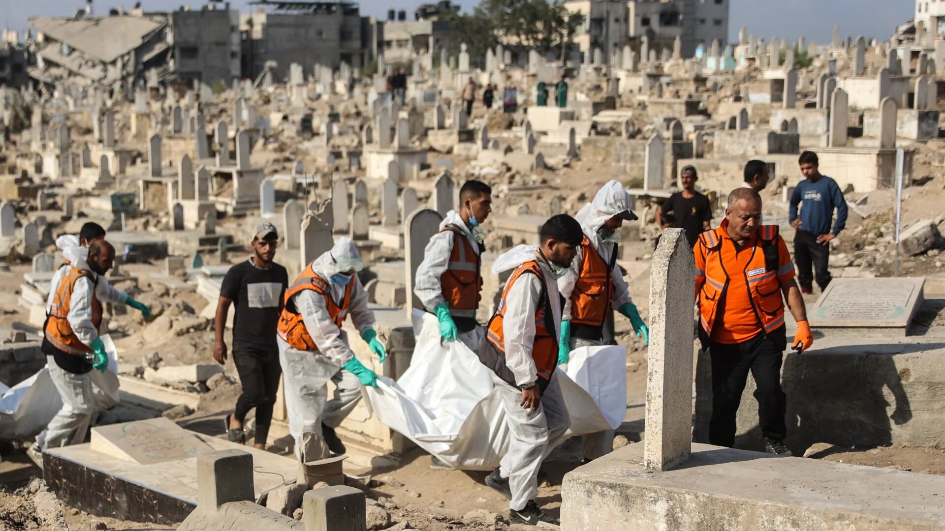 Civil defence workers and relatives carry the remains of the Shahebar family for burial at Sheikh Shaaban Cemetery in Gaza City on 24 October 2025, after around 80 members of the family were killed in an Israeli air strike on the Sabra neighbourhood in November 2023 (Omar Al-Qattaa/AFP)