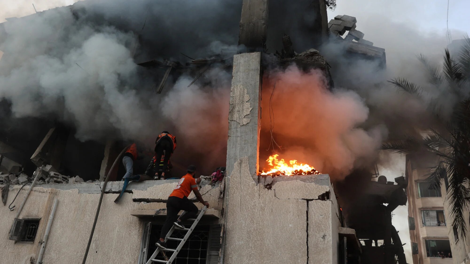 Civil defence personnel search a burning house targeted by Israeli air strikes in Gaza City, on 22 November 2025 (AFP/Omar al-Qattaa)