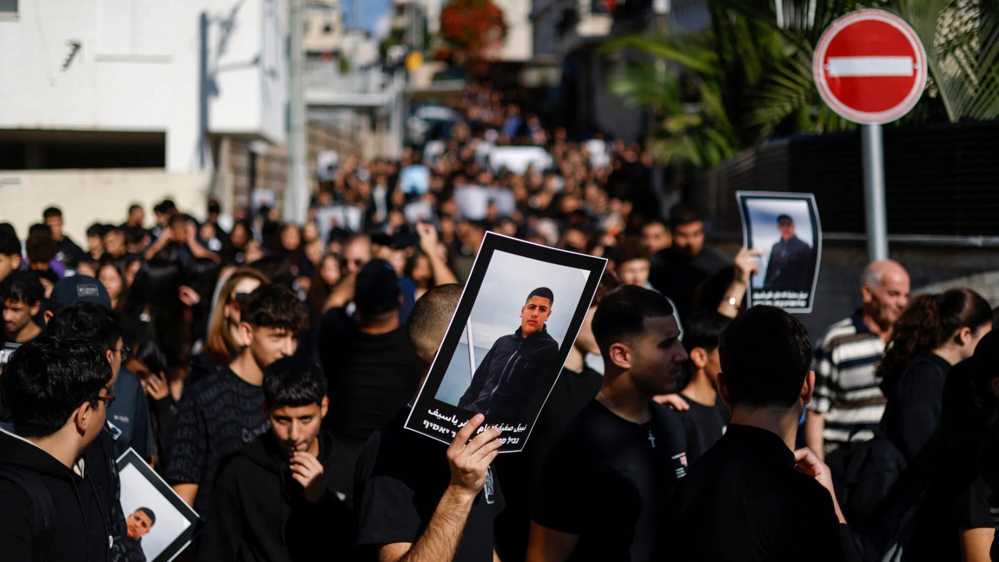 Palestinian residents of Kfar Yasif in Israel protest rising murders on 2 December 2025, holding posters of 16-year-old Nabil Safiyeh, killed last week (AFP/Jalaa Marey)