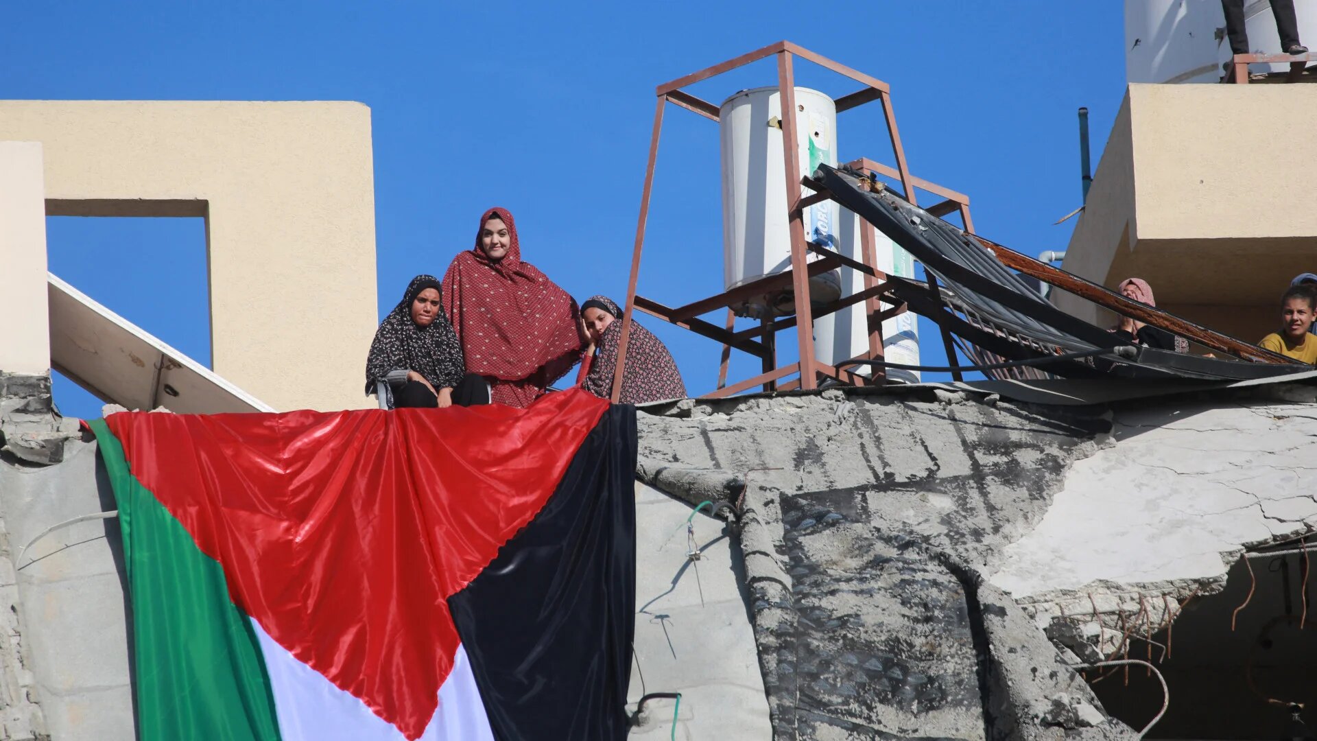 A Palestinian flag hangs from a building destroyed by Israeli bombardment in Khan Yunis, southern Gaza Strip, 2 December 2025 (Bashar Taleb/AFP)