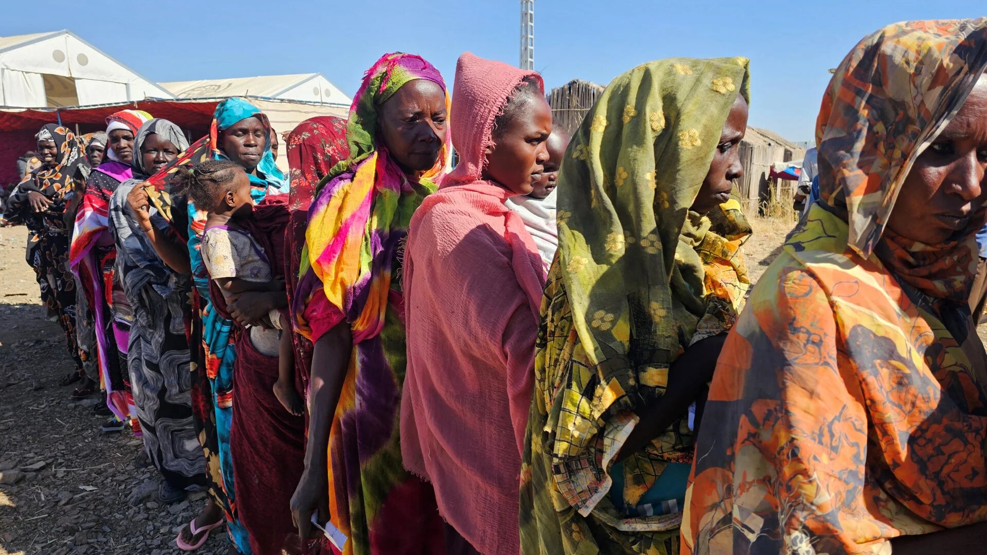 Sudanese displaced from the Heglig area in western Sudan wait to receive humanitarian aid at the Abu al-Naga displacement camp in Gedaref State, some 420km east of the capital Khartoum, on 30 December 2025 (Abdulrahman Gumaa/AFP)