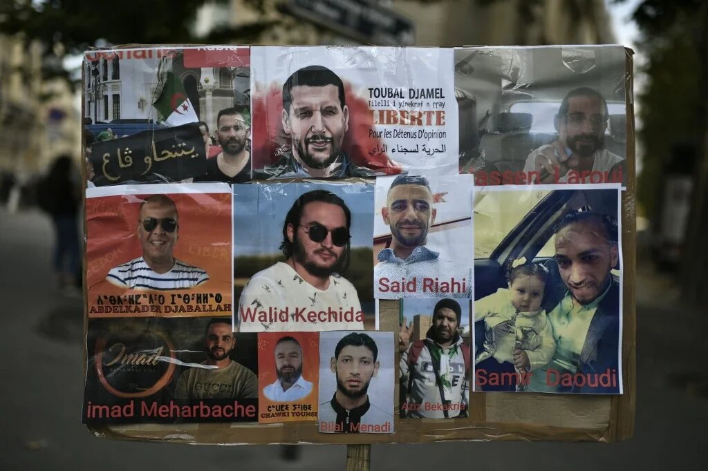 Une photo prise le 12 août 2020 montre des portraits de détenus algériens lors d’une manifestation à Paris devant l’ambassade d’Algérie (AFP)