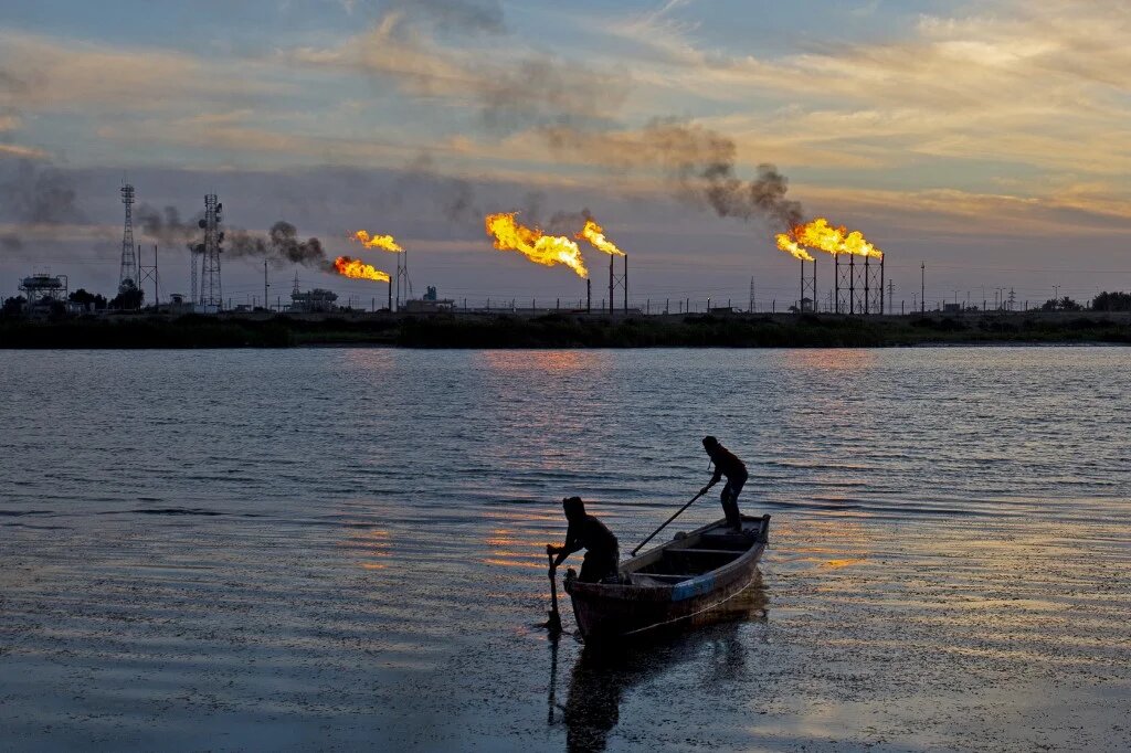 Des pêcheurs irakiens naviguent devant le champ de Nahr Bin Omar, au nord du port de Bassorah, dans le sud de l’Irak, le 21 janvier 2021 (AFP/Hussein Faleh)