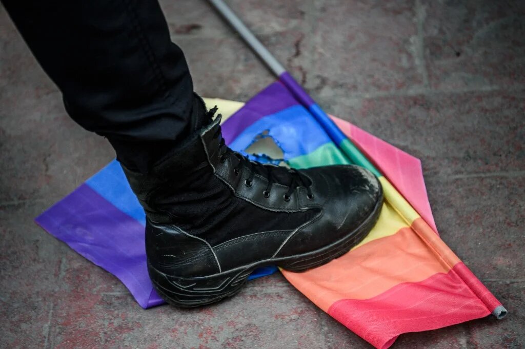 Un policier turc piétine le drapeau arc-en-ciel lors d’un rassemblement de la communauté LGBT à Istanbul, le 19 juin 2016 (AFP)